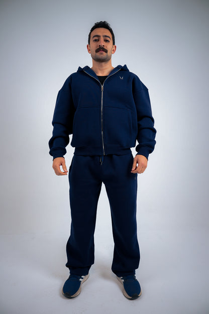 Model wearing a navy-blue RAVIX tracksuit on a light gray background