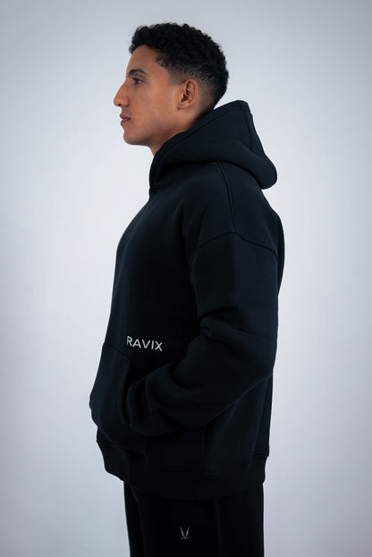 Person wearing a black hoodie with 'RAVIX' branding on a light gray background