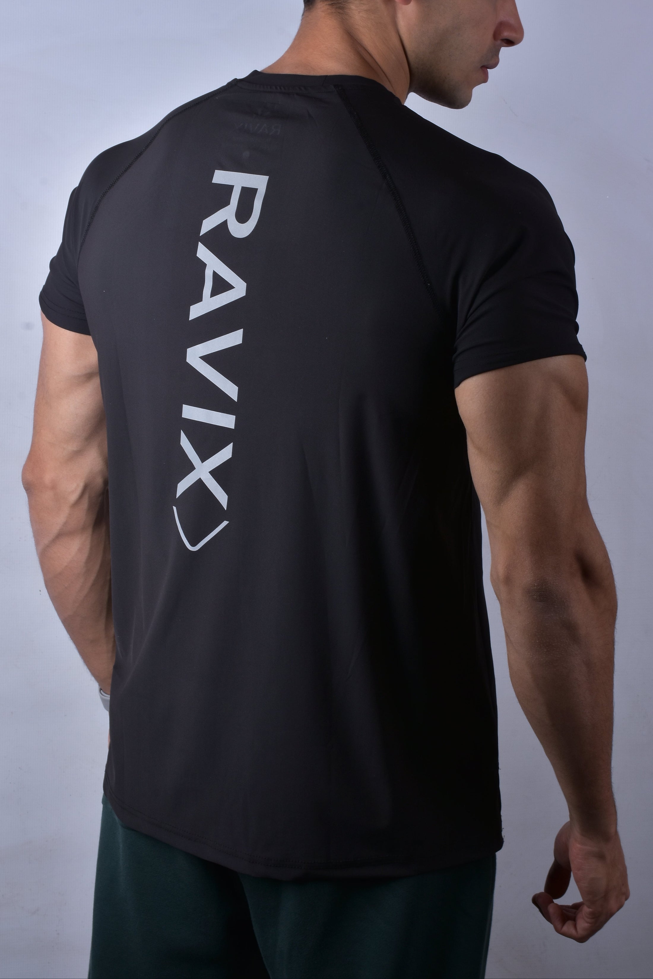 Person wearing a black t-shirt with 'RAVIX' branding on the back against a plain background
