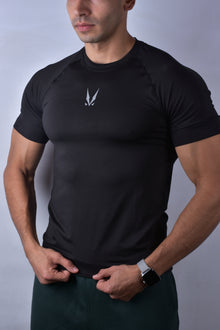 Man wearing a black compression t-shirt with 'RAVIX' logo on a gray background