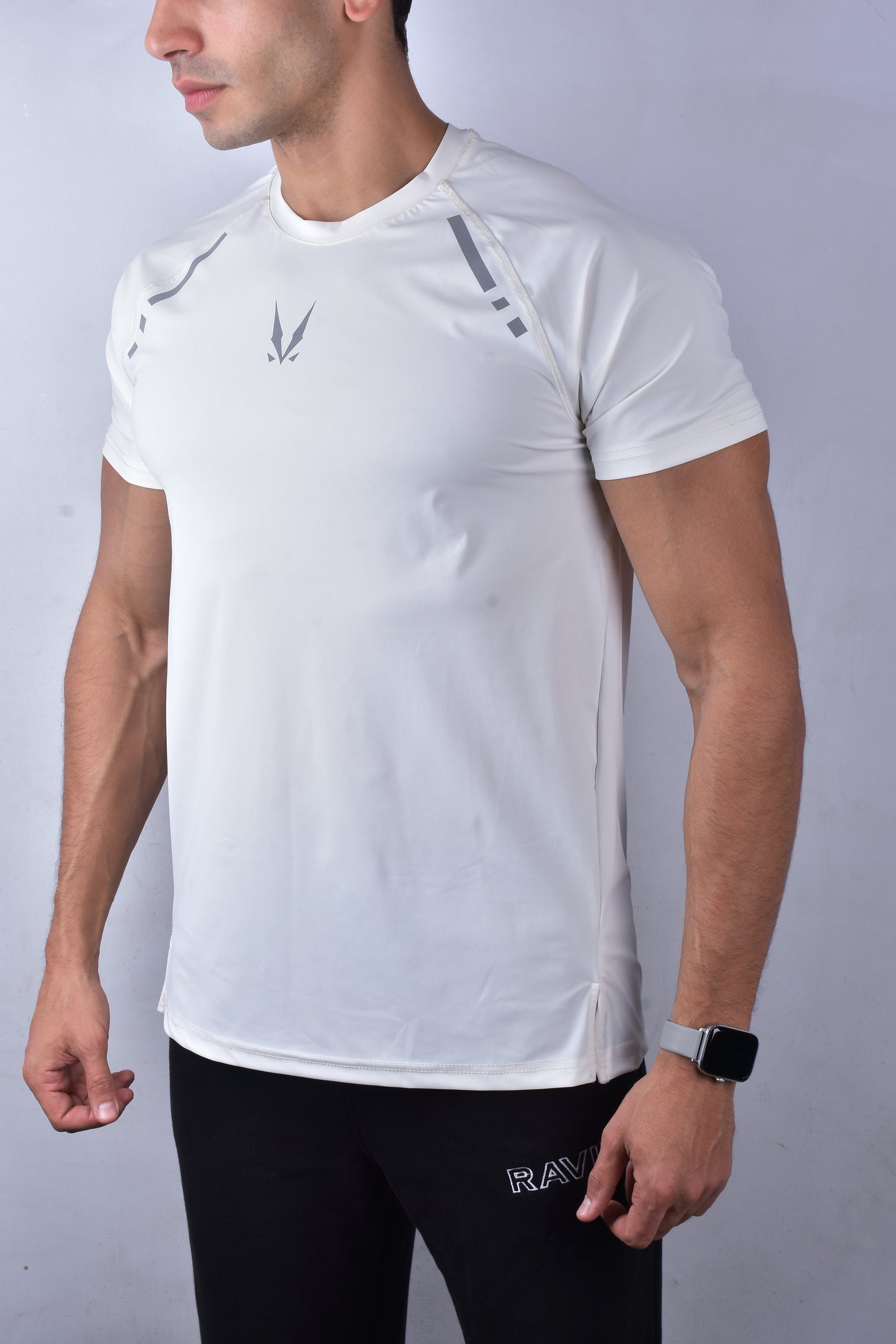 Person wearing a white athletic shirt with 'RAVIX' logo on a plain background